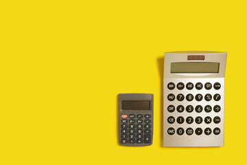 two calculators on a yellow background