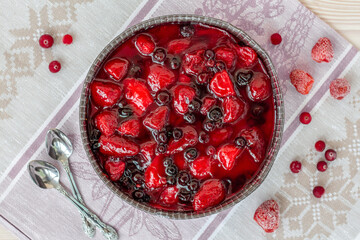 top view of summer round berry pie on linen cloth, a cake decorated with strawberries and black currants in jelly, healthy vegan dessert