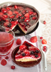 a piece of berry pie for breakfast, a round cake decorated with strawberries and black currants in jelly, healthy nutrition, top view of vegan dessert