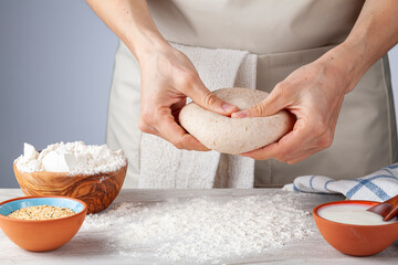 Preparation of homemadeTurkish flat bread, pide or pizza base in the kitchen. A woman chef is...