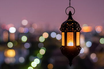 Hanging lantern with night sky and city bokeh light background for the Muslim feast of the holy month of Ramadan Kareem. - obrazy, fototapety, plakaty