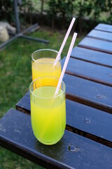 Summer fresh cold drink beverages. Ice Lemonade, orange juice and spirits in glasses  on the table outdoor. Refreshing cocktail. It is called 