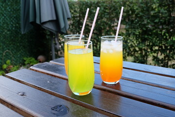 Summer fresh cold drink beverages. Ice Lemonade, orange juice and spirits in glasses  on the table outdoor. Refreshing cocktail. It is called 