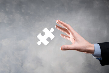Businessman hands connecting puzzle pieces representing the merging of two companies or joint...