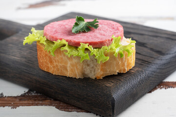 Sandwiches with lettuce leaves and sliced salami sausage on a wooden Board.