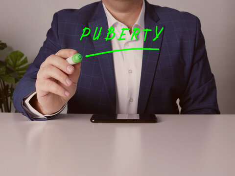 Merchant writing PUBERTY on screen by a green pen