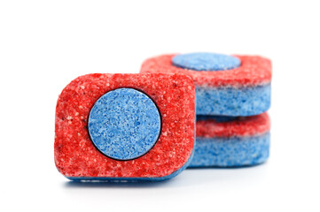 three dishwasher tablets close up on white isolated background