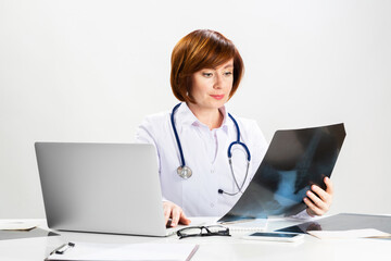 Beautiful doctor looking at x-ray scan in office