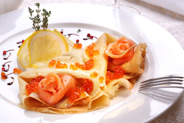 Tiny pancakes with caviar and salted salmon. Restaurant meal.