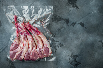 Vacuum sealed fresh lamb chops for sous vide, on gray stone background, top view flat lay , with copyspace  and space for text