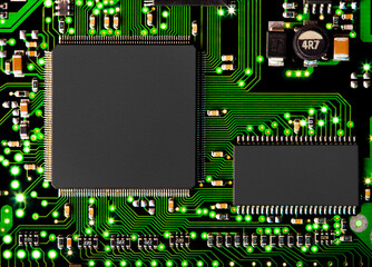 Close up of computer circuit board in green with transistors and chip