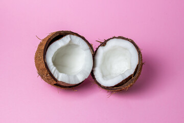 Isolated coconut on a pink background. The two halves of the coconut are in the center of the image. Healthy fruit