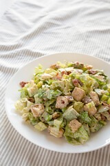 Homemade Bacon Avocado Caesar Salad with Cheese and Croutons, low angle view. Copy space.