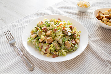Homemade Bacon Avocado Caesar Salad with Cheese and Croutons, low angle view.