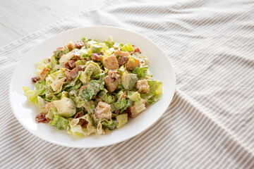 Homemade Bacon Avocado Caesar Salad with Cheese and Croutons, low angle view. Copy space.