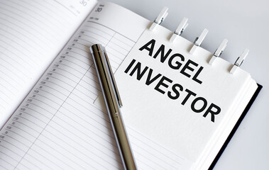 text Angel Investor on the short note texture background with pen