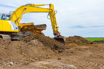 Fototapeta na wymiar Excavator is loading a truck with ground on building site