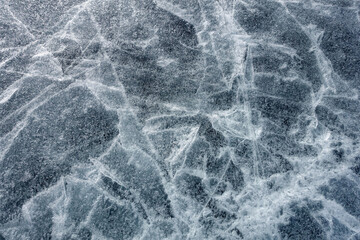 The surface texture of the ice. A cracked ice floe. Winter cold background