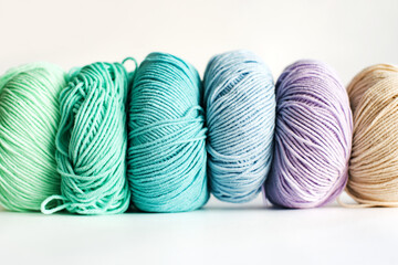  Women's hobby. Crochet and knitting.  Multicolored skeins of yarn on a white background. Studio shooting.