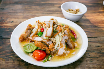 Famous Thai food, papaya salad, Somtum, Papaya Pok Pok. Closeup Thai Green Papaya Salad with Fried pork
