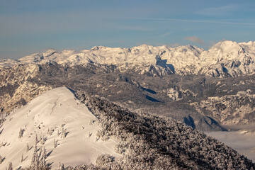 Skiers on small peak with Bohinj valley in the background
