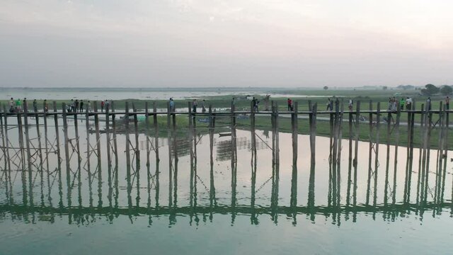 Side view of famous teakwood U Bein Bridge during sunset, truck left