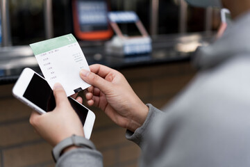 Women wearing masks use mobile phones to buy tickets