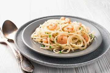 Spaghetti shrimp scampi with parsley in a plate on wooden background