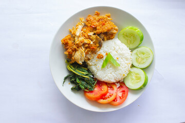 Fototapeta na wymiar ayam geprek or chicken crush or chicken smashed is indonesian food made from made fried chicken pounded with chilli and garlic flavour and served with vegetables and rice, isolated on white background