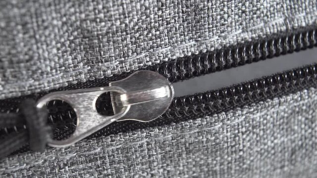 Unzipping the zipper, unpacking the suitcase. Macro shot. Travel concept