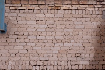 The brick wall of the building is made of white brick. Rear view. Blue chimney stack.