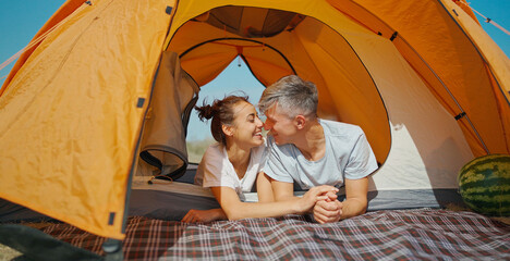 Cute happy authentic moments couple in camping travel vacation. Casual man and woman lying in tent together. Concept wellness quality life and slow living - 417793319
