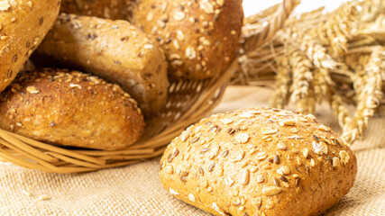 Home baked bread. Rye bakery with crusty loaves and crumbs. Fresh rustic traditional bread with wheat grain ear or spike plant on natural cotton background. Design element for bakery product label.