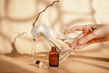 Young woman is experimenting with cosmetics. Essence for skin health on a beige  background....