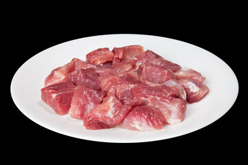 Pieces of raw meat on a white plate
