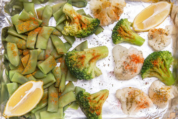 Fototapeta na wymiar Baked in foil broccoli, string bean and cauliflower with spices and lemon close up. Vegan vegetarian healthy diet food 