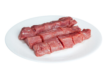 Pieces of raw meat  on a white plate