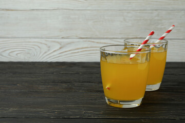 Glasses of orange soda on wooden background