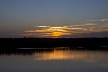 Obraz premium Dramatic and colorful sunset over a forest lake reflected in the water. Blakheide, Beerse, Belgium. High quality photo