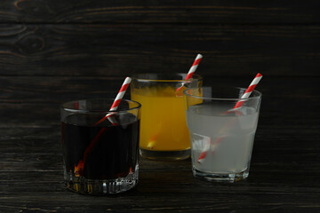 Glasses of different soda on wooden background