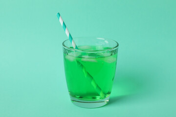 Glass of green soda on mint background