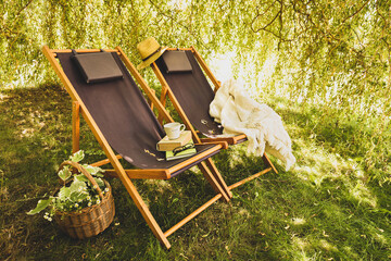 Two wooden deck chairs - summer outdoor leisure in the garden