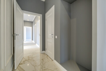 Fototapeta na wymiar long white empty corridor in interior of entrance hall of modern apartments, office or clinic