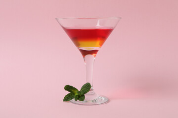 Cocktail glass with strawberry and orange jelly on pink background