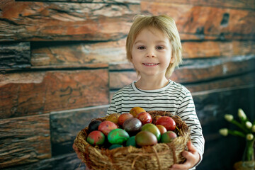 Fototapeta premium Sweet toddler child, cute boy playing with colorful easter eggs