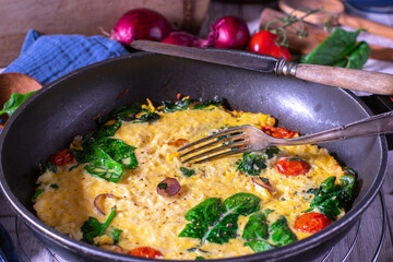 Rice omelet with spinach, tomatoes and red onions
