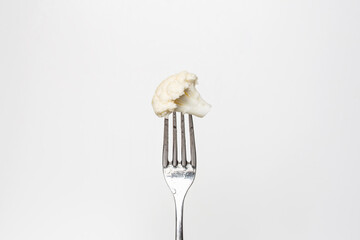 Photo of a fresh cauliflower on a fork isolated on a white background, part of a series.