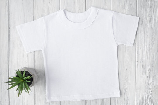 White tshirt mockup with succulents on wooden table background. Template, flat lay
