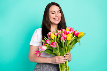 Photo of cheerful young girl happy positive smile birthday gift flowers bouquet isolated over turquoise color background