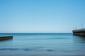 Obraz premium Sea blue water, horizon, pier, breakwaters